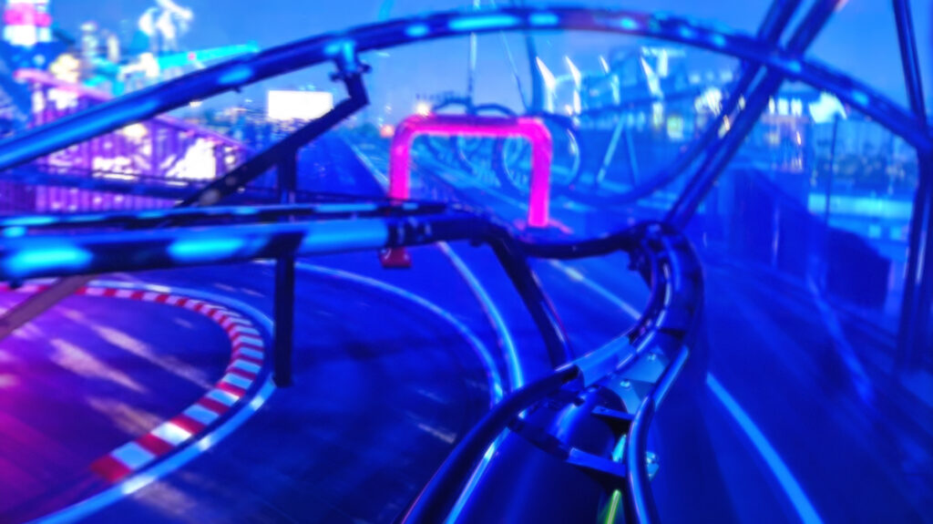 A dark, neon pov image of  Lagoon's J3 Grand Prix coaster